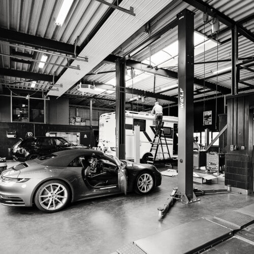 Zwart-witte auto garage met een Porsche